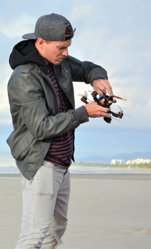 man, drone, the pilot of the drone, jacket, cap, jeans, beach, sand, dawn, technology, nature, blonde, white, adventure